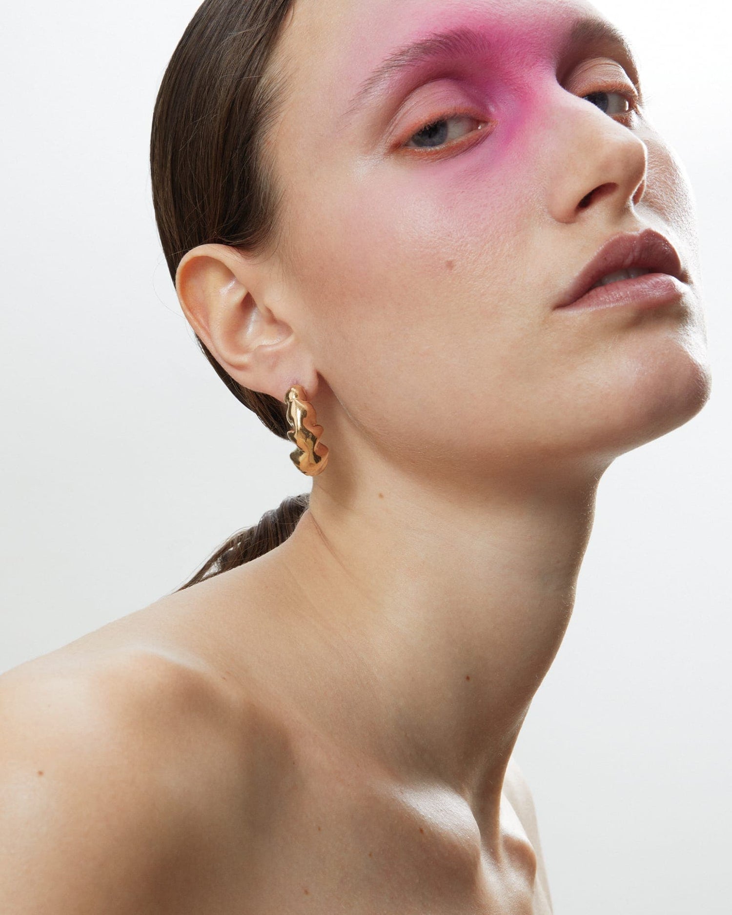 Model wearing LMJ Bubble Maxi earrings in polished gold, sculpted into bold organic forms.