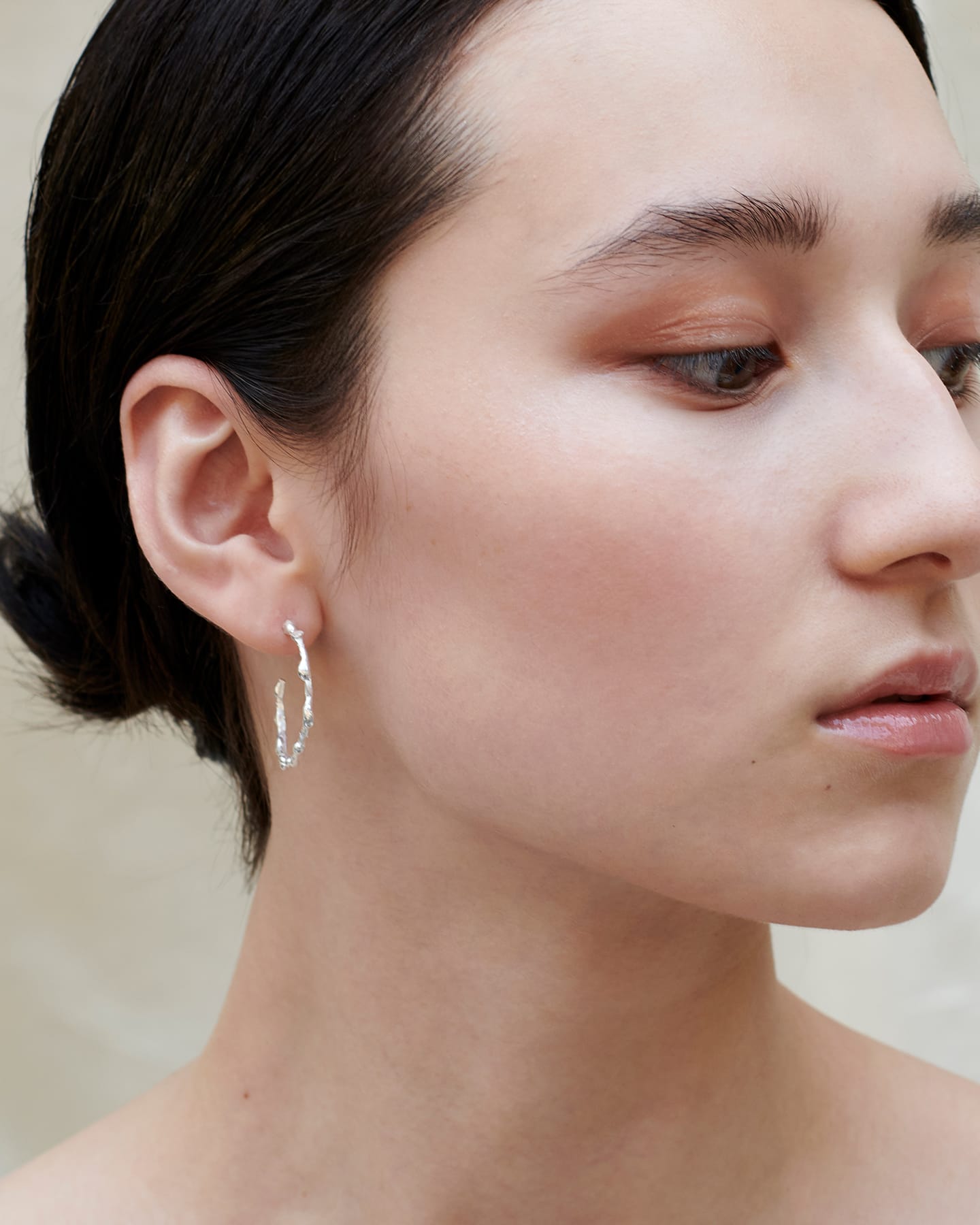 Model wearing silver drop earrings, showcasing the scale and fit.