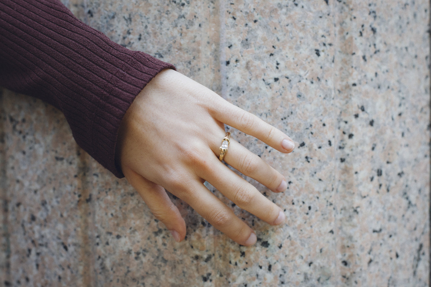 Nest Hug Ring worn on a hand, 18k gold engagement ring with an oval diamond
