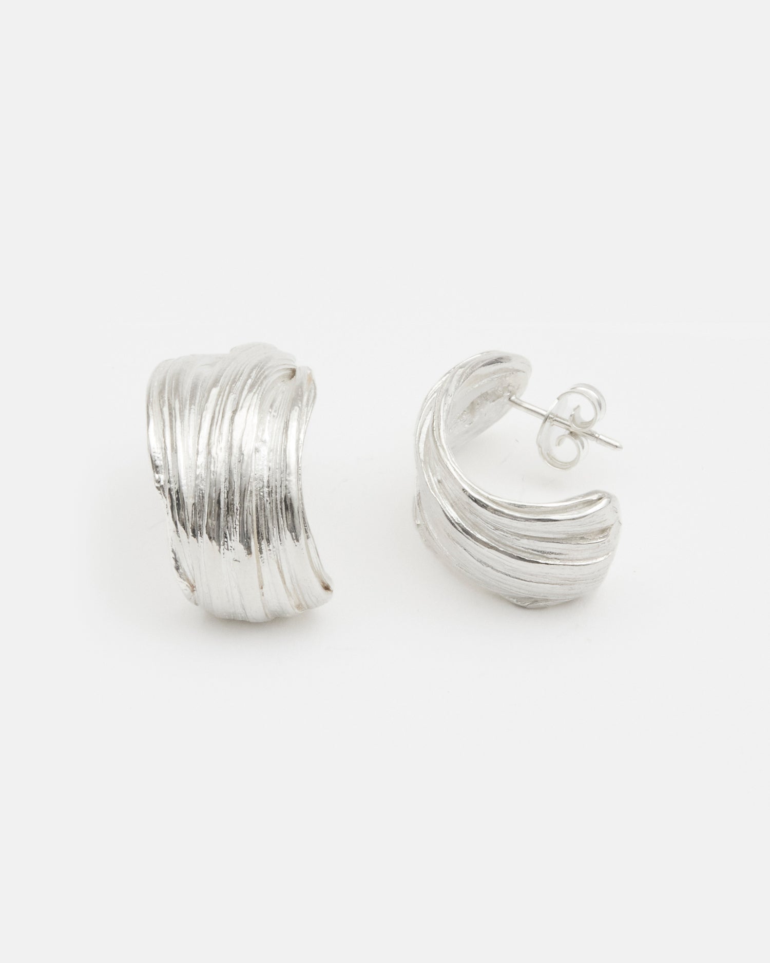 Model wearing LMJ Twist Earrings in silver – elegant sculptural curves