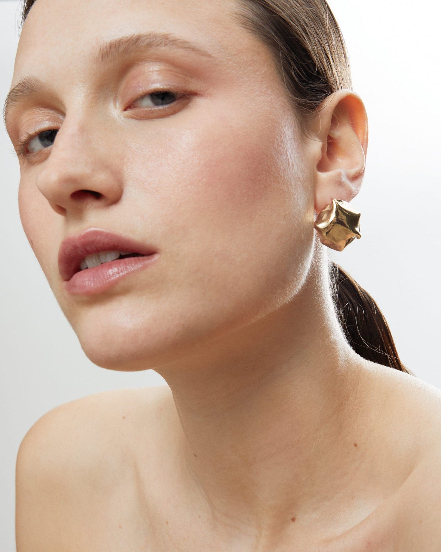 Model wearing LMJ Balloon Earrings in gold - bold sculptural styling