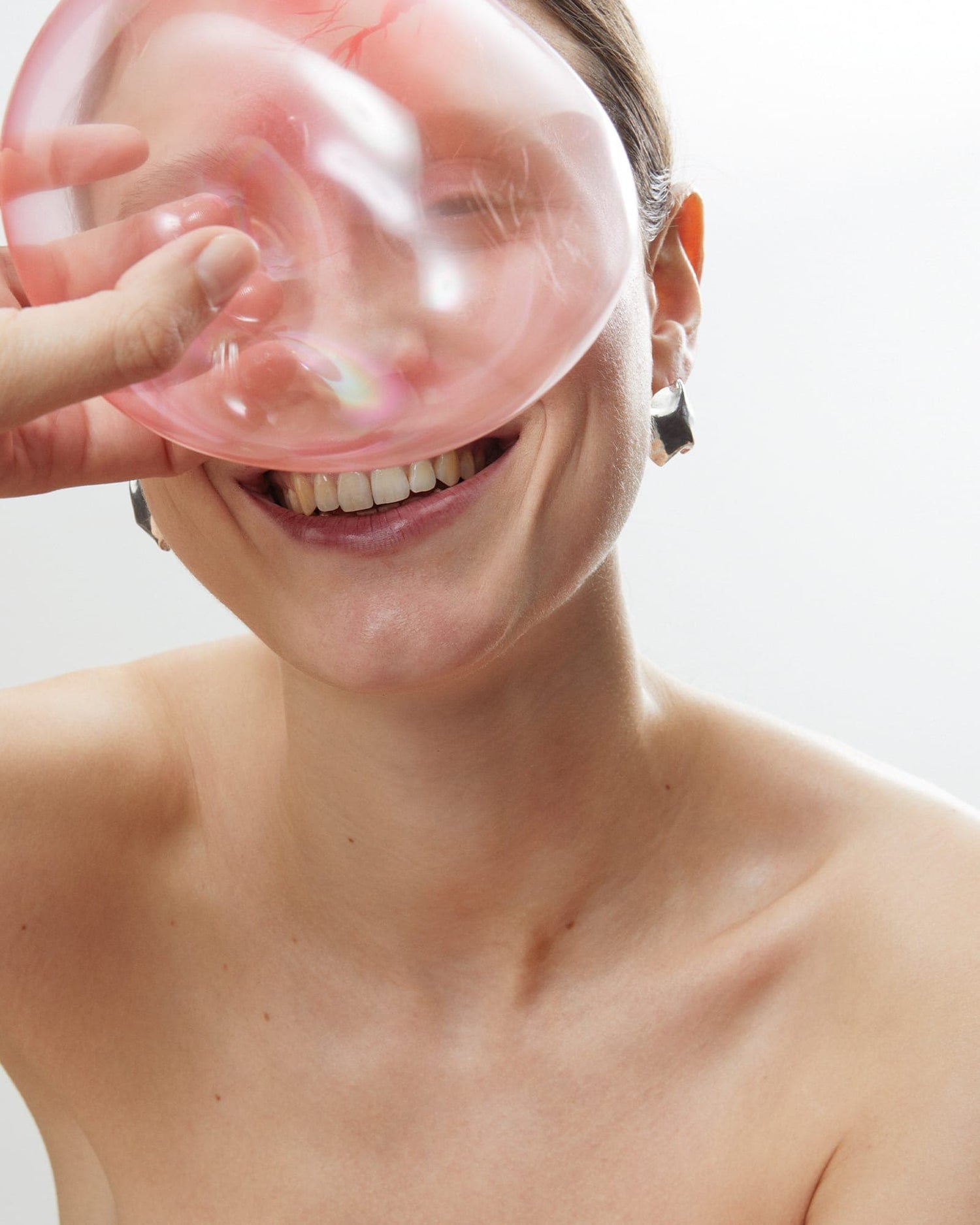 Model smiling in LMJ Balloon Earrings in silver - joyful organic design