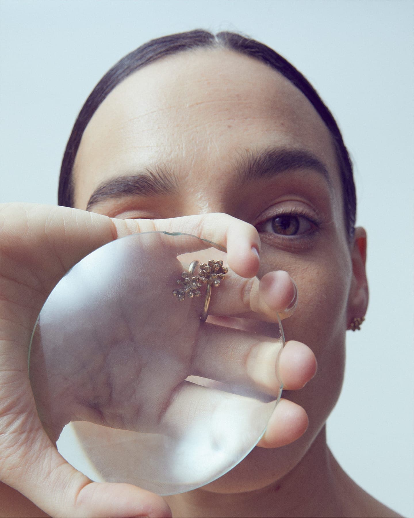 Model wearing LMJ Bouquet Ring in gold, viewed through a round lens