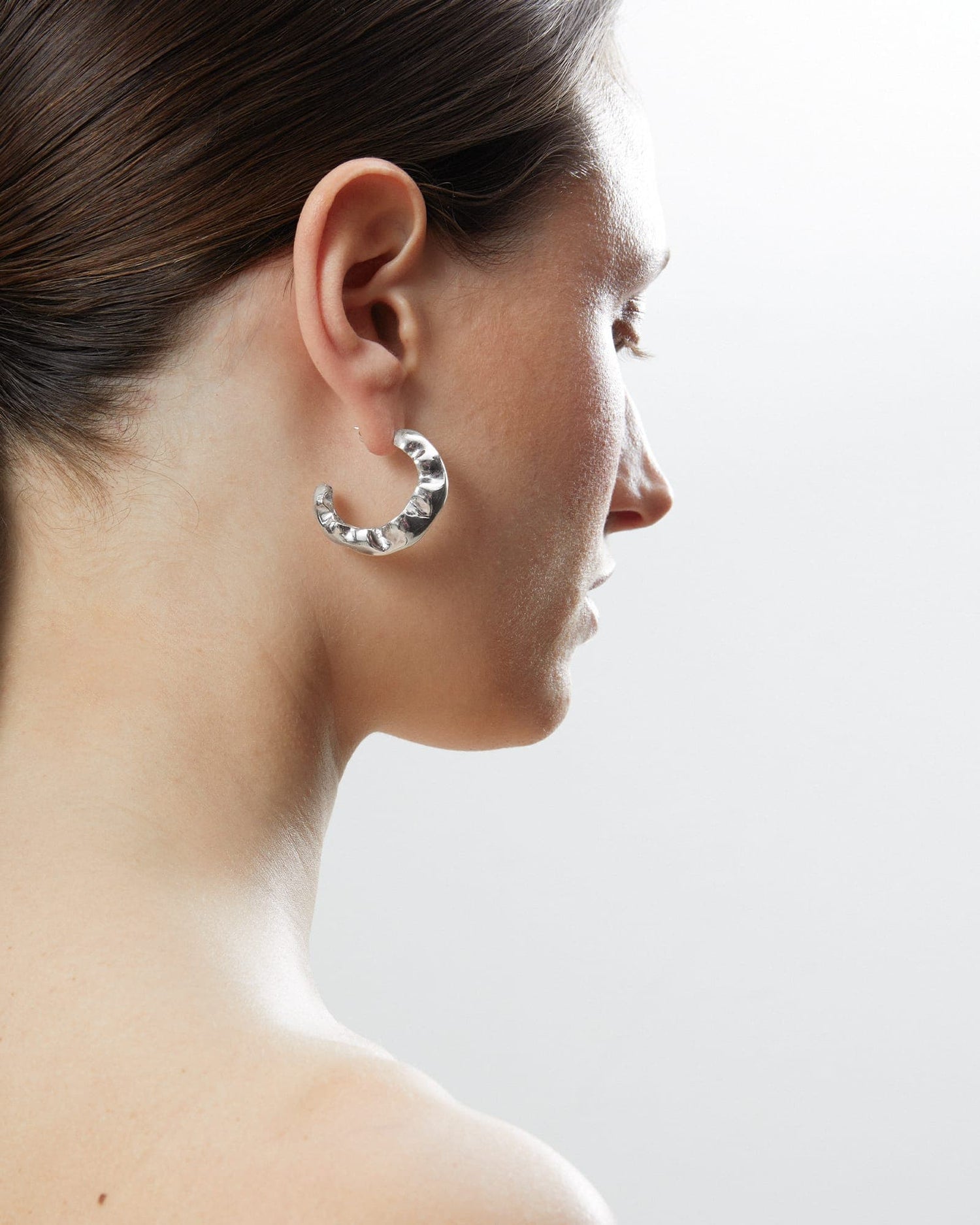 Model wearing LMJ Bubble Maxi earrings in polished silver, sculpted into bold organic forms.
