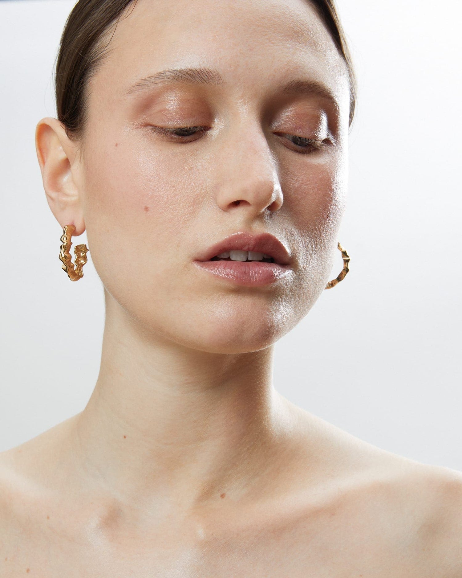 Model wearing LMJ Bubble Mini earrings in gold, pairing their raw elegance with minimal styling.
