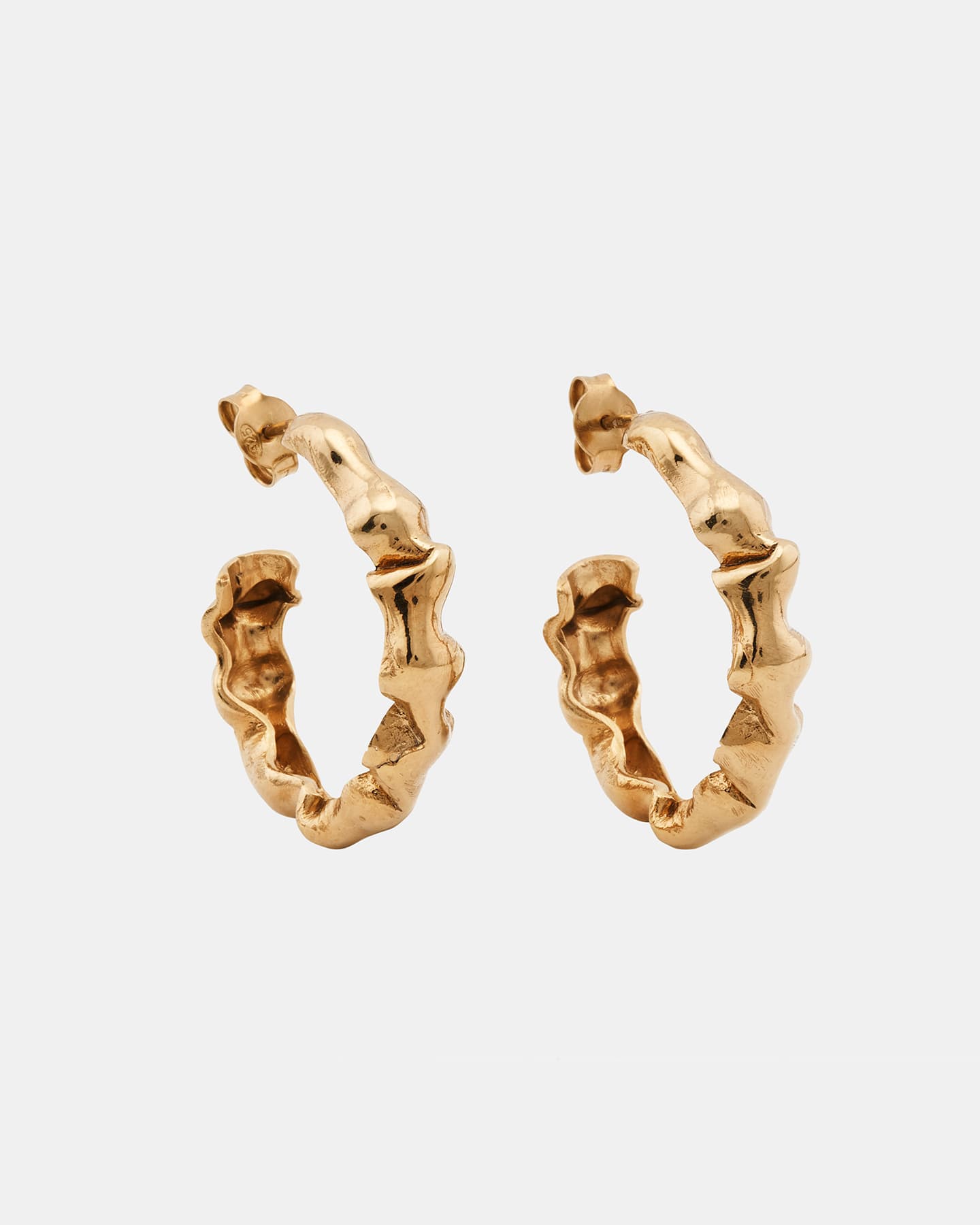 Alternate angle of LMJ Bubble Mini earrings in warm gold, floating over glossy blue styling gel.