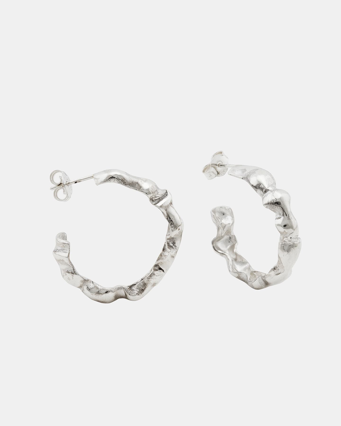 Sculptural silver LMJ Bubble Mini earrings shot in symmetry, showing off the high-shine surface.