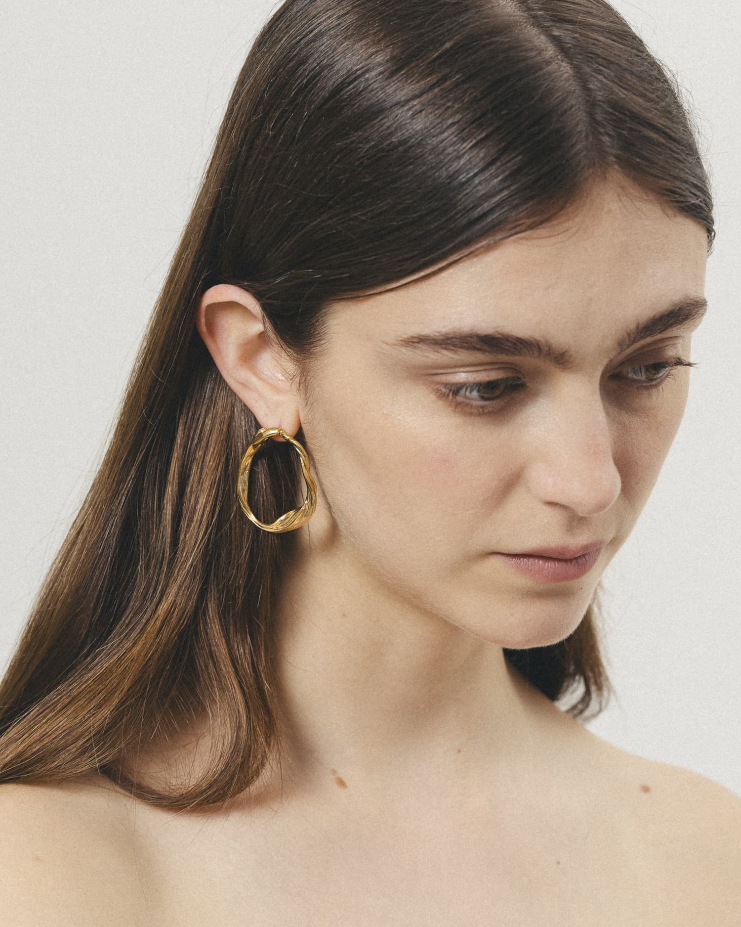 Model wearing LMJ Curl Earrings in gold – bold hoops with a natural twist