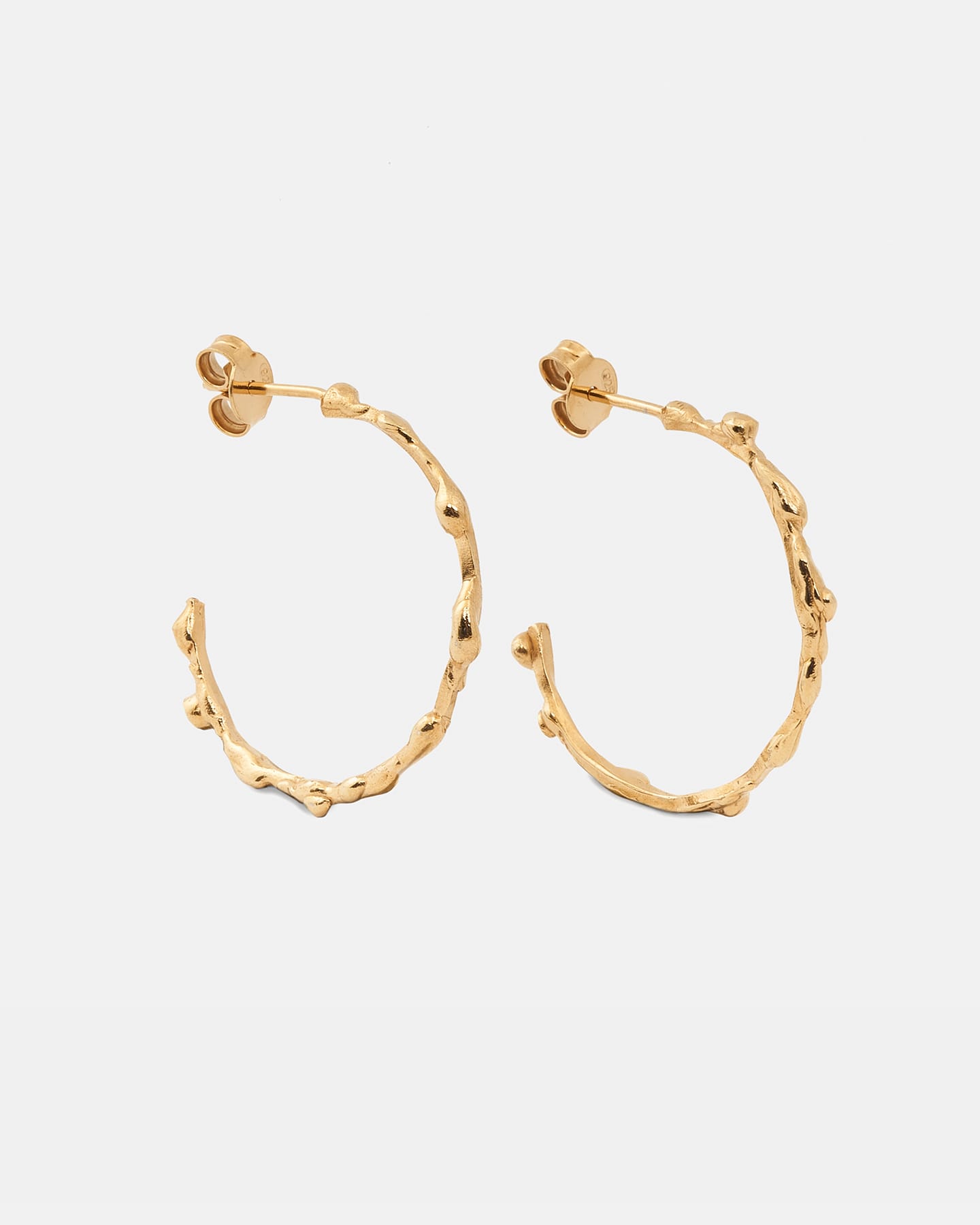 Gold drop earrings in a vertical layout highlighting the organic form.