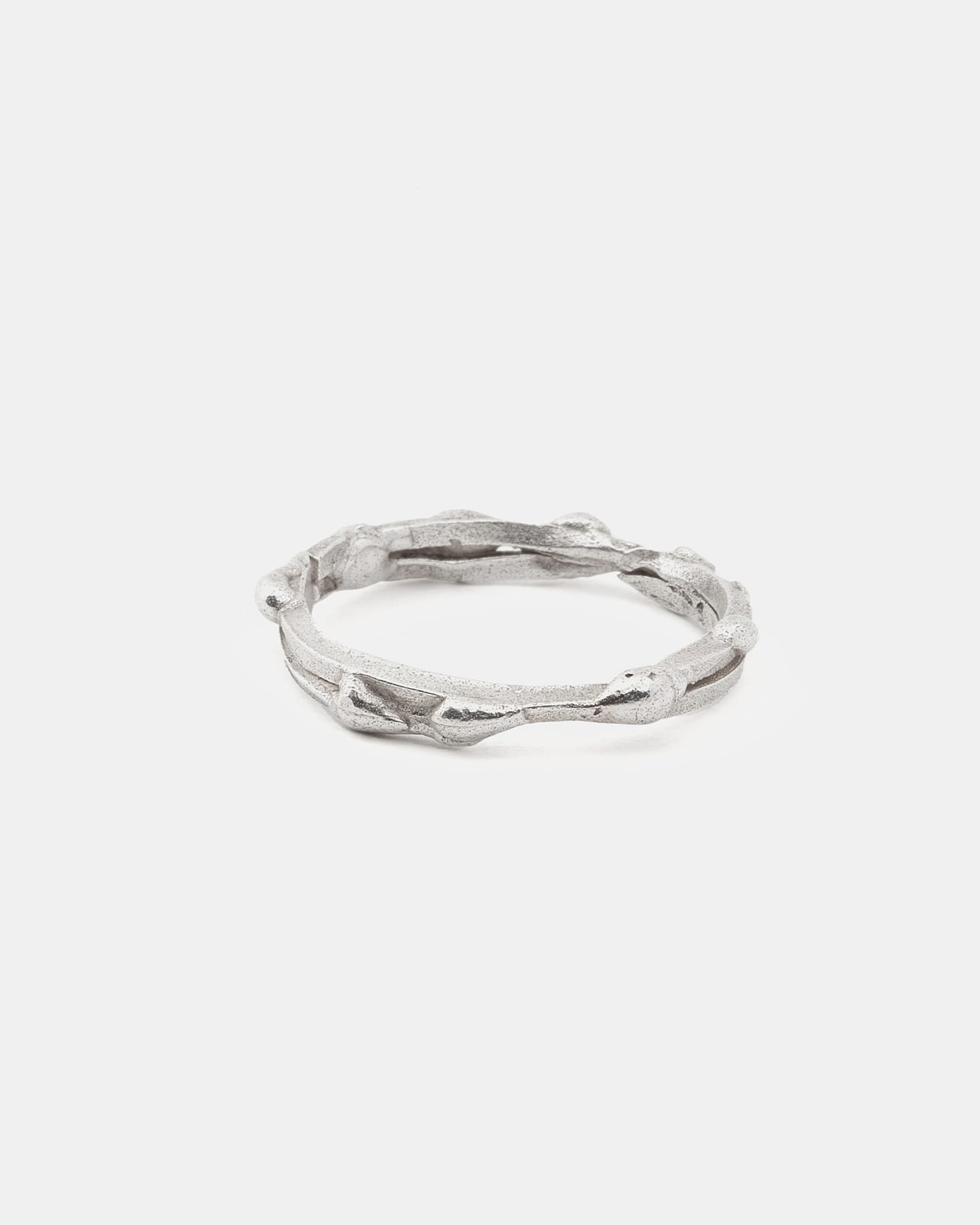 Silver drop ring with organic details, horizontal front view.