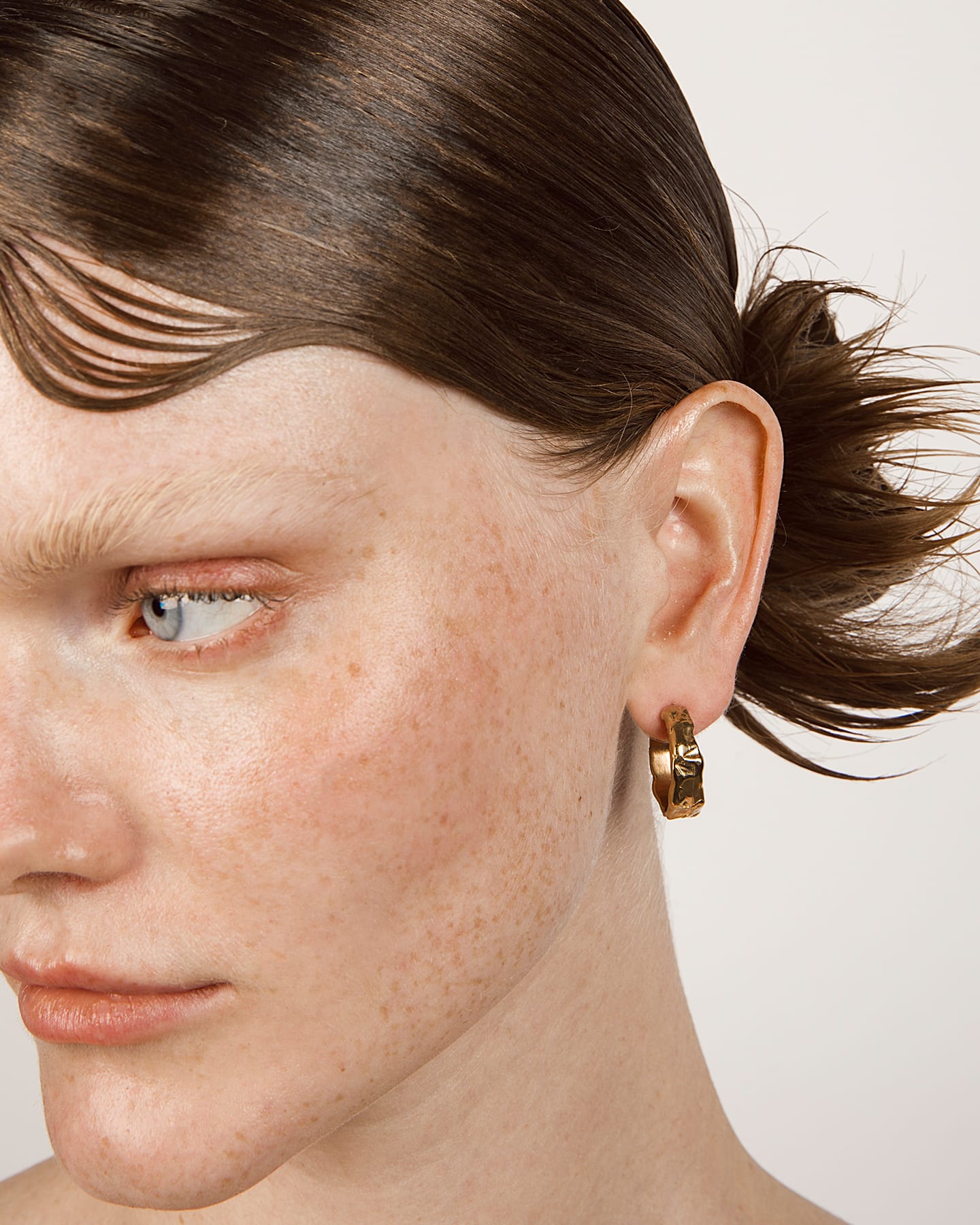 LMJ Earth Hoops mini earring in gold worn by a model