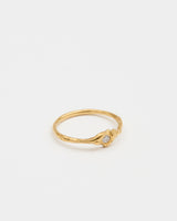 Gold ring with a small gemstone on a light gray background