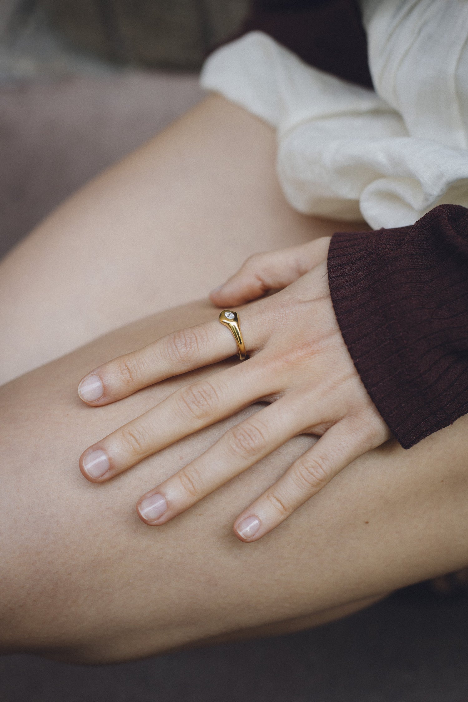 Orbit Mini Ring worn on a hand, 18k gold engagement ring with an oval diamond