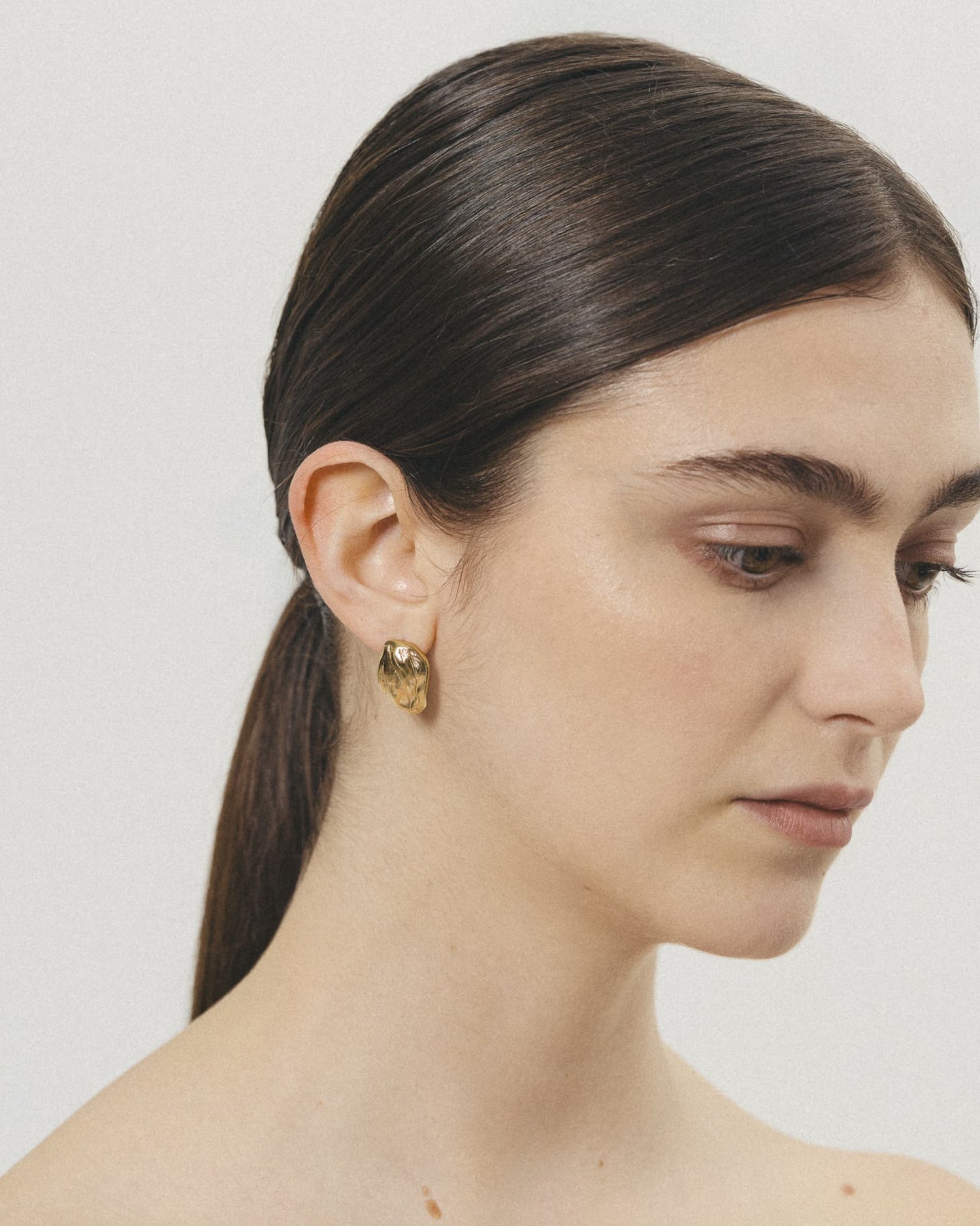 Model wearing LMJ Petalo Mini Earrings in gold – subtle statement with organic charm
