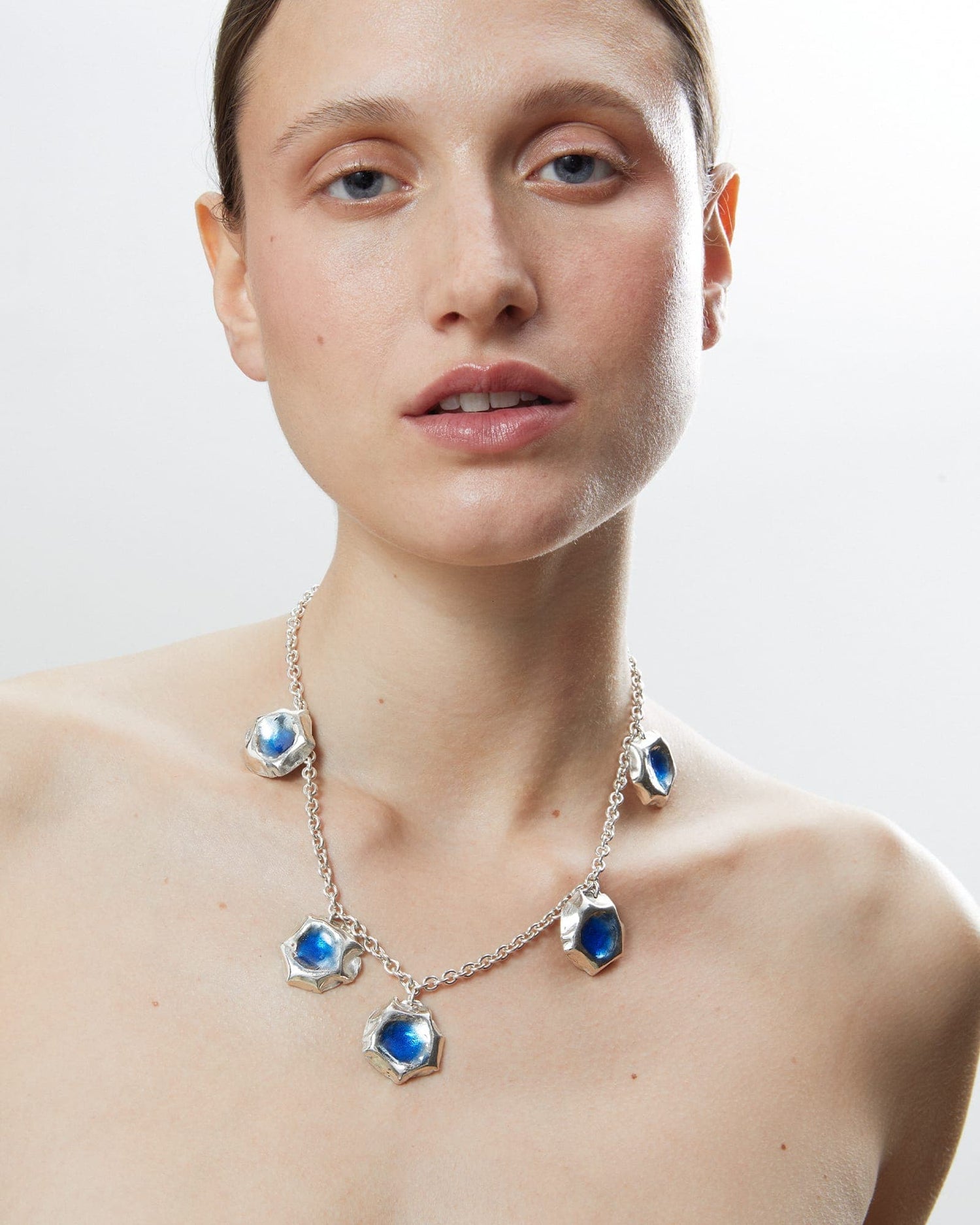 Model wearing LMJ Puff Necklace with multiple blue enamel pendants
