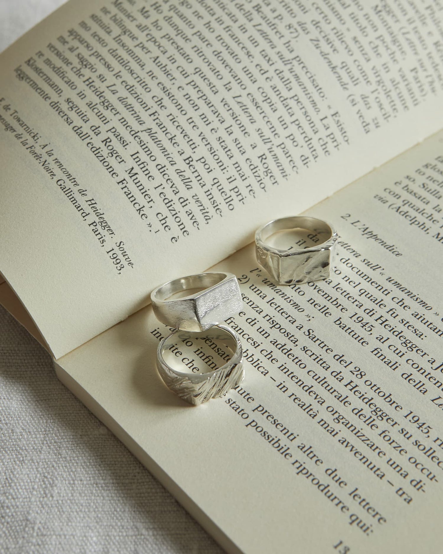 LMJ Rock, Flow and Square silver rings on an open book