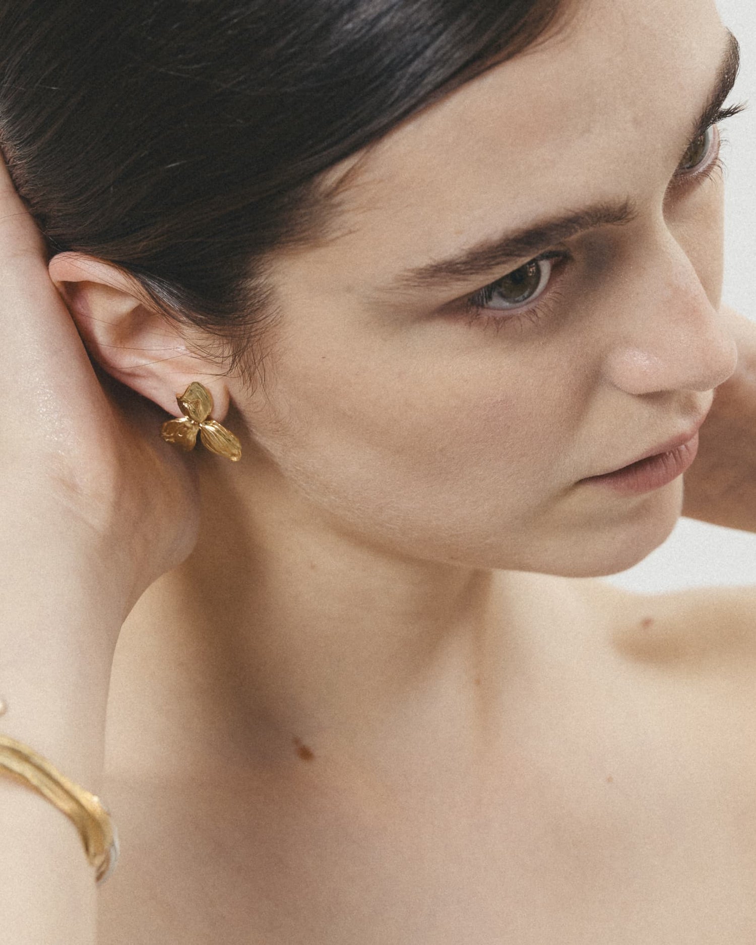 LMJ Trifoglio Mini Earrings in gold – worn by model with hands in hair, botanical and bold