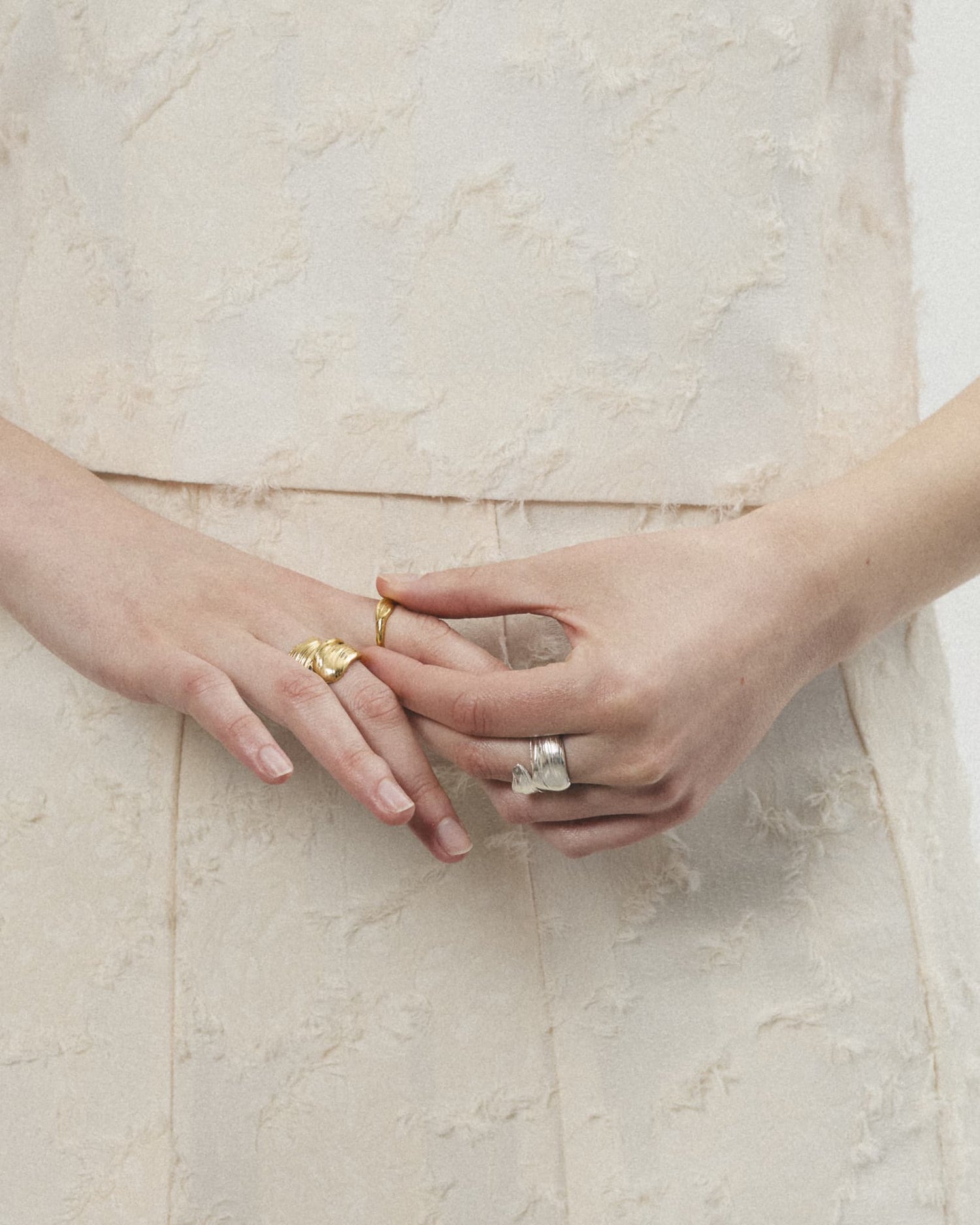 Model's hands adorned with LMJ Twist Rings – gold and silver in harmonious play