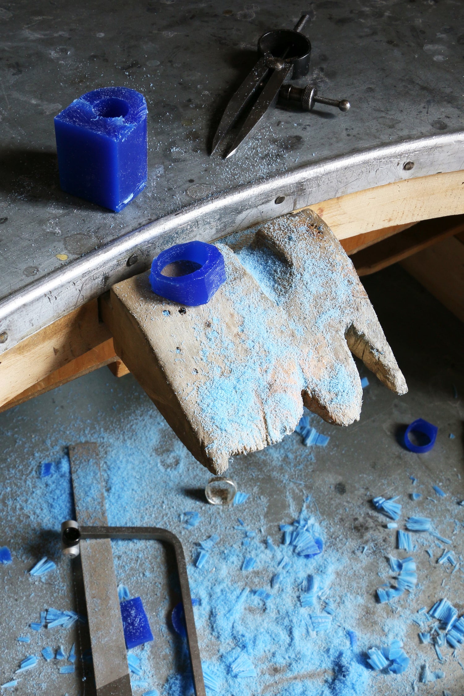 Workbench with blue wax pieces and tools during the LMJ wax carving jewelry workshop.