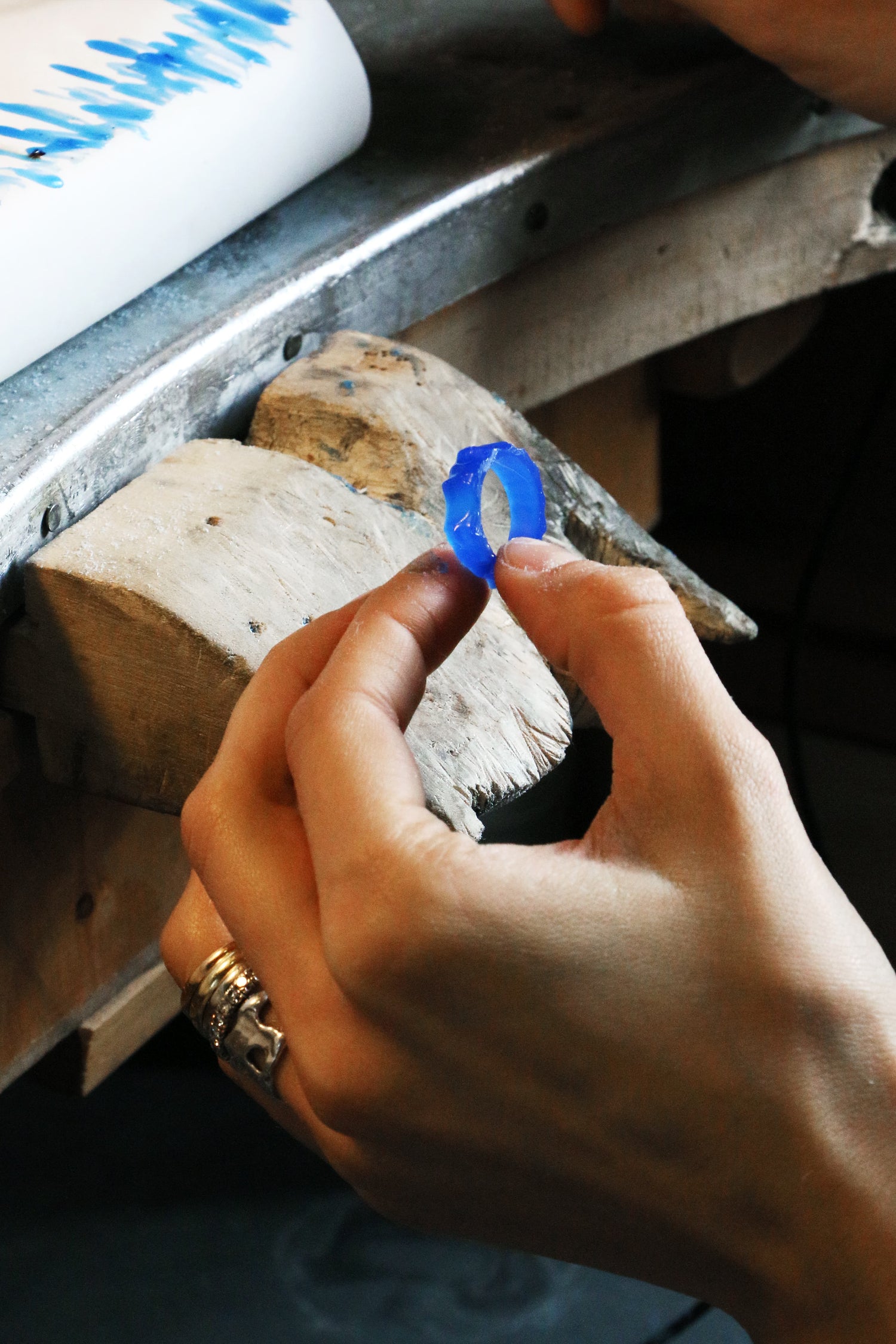Hand holding a blue wax ring during the LMJ wax carving jewelry workshop